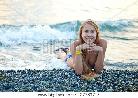 Young beautiful girl in a bathing suit lying on the beach on vacation