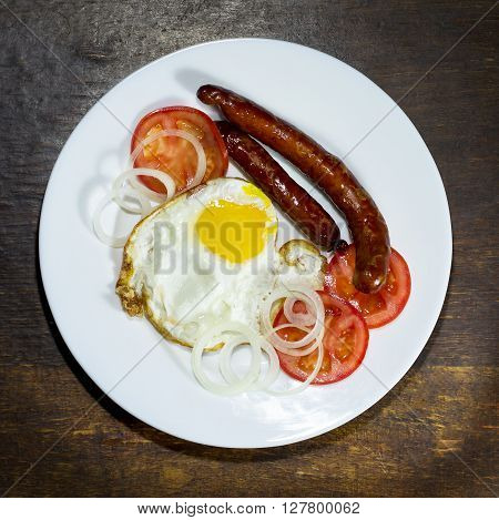 Fried eggs in a white plate  on wooden background