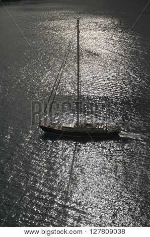 A sailboat sails along the shorline of the coast of Grand Cayman