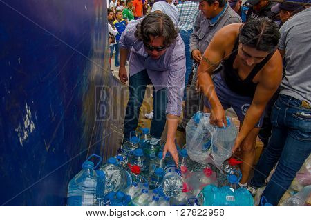 Quito, Ecuador - April, 17, 2016: Unidentified volunteers of Quito providing disaster relief food, clothes, medicine and water for earthquake survivors in the coast.