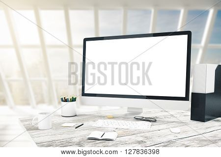 Blank computer screen on wooden desktop with various items in interior with panoramic windows. Mock up 3D Rendering