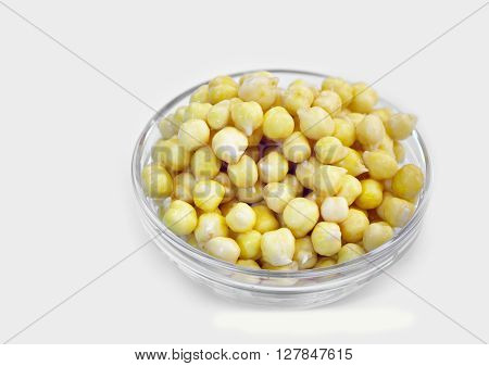 Germinated chickpeas in a transparent glass jar on a white background