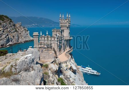 Landmark Swallow's Nest located in Gaspra: between Yalta and Alupka towns on the Crimean peninsula. Beautiful building is situated on rock against blue sea and sky background.