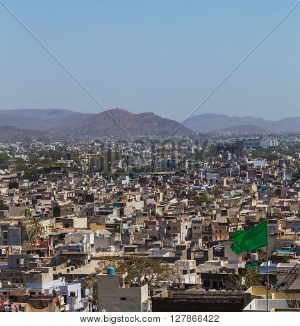 A view over rooftops in central Udaipur during the day. The Machla Hills can be seen in the distant.