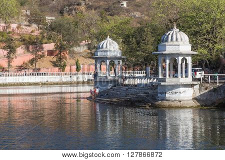 UDAIPUR INDIA - 20TH MARCH 2016: A view of the Doodh Talai Lake in Udaipur during the day. Part of the architecture at the waterfront and people can be seen.