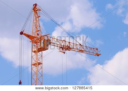 Big yellow stationary hoist on construction site blue sky and white clouds