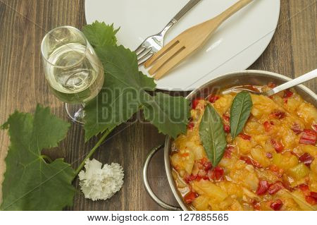 chicken with zucchini,zucchini stew with chicken,glass of wine and vine leaf