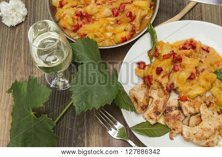 chicken with zucchini,zucchini stew with chicken,glass of wine and vine leaf