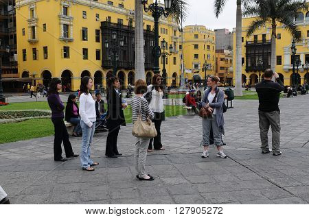 20 November 2010- Plaza de armas Lima Peru. Tourists standing on the Plaza de Armas near the Headquarters of the Caretas magazine.