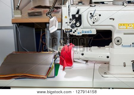 Single-needle lockstitch sewing machine with bag platform with triple unison promotion for medium and heavy materials