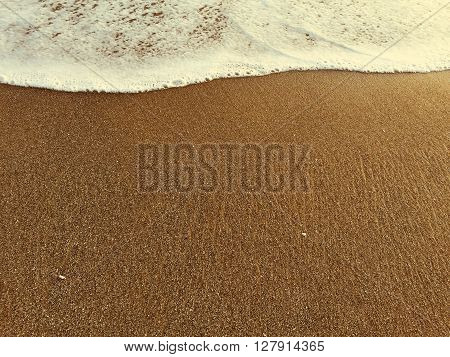 Foam of wave and yellow sand beach, high tide, warm sea and sand beach