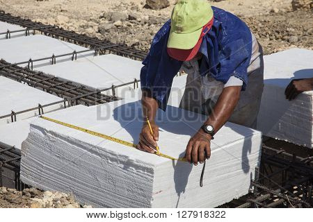 Worker Taking measures of an Iron framework and polyurethane  to build a foundation for a building