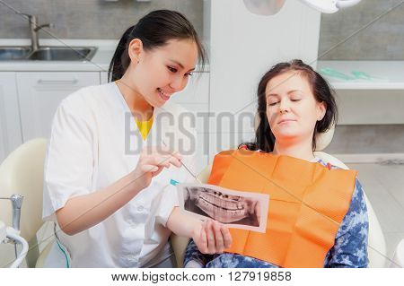 Dentist showing x-ray to a patient on the office