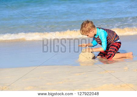 little boy play with sand on summer beach, family vacation