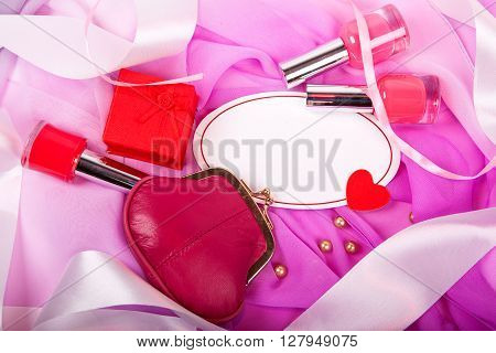 bottle of nail polish on a pink matter with white satin ribbons and sign for text