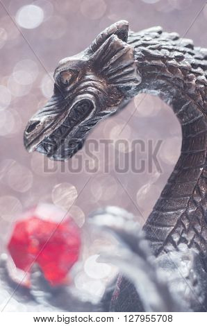 An old antique metallic dragon is holding a bead.