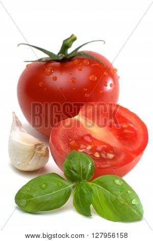 Tomatos with garlic clove and basil isolated on white