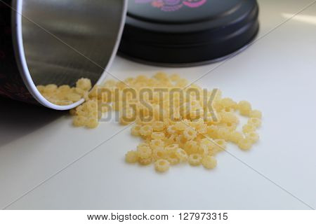 Small dry pasta noodles in tin on background