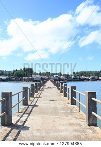 old concrete bridge to dock fisherman village pier in tranquil sea destination Trang Thailand