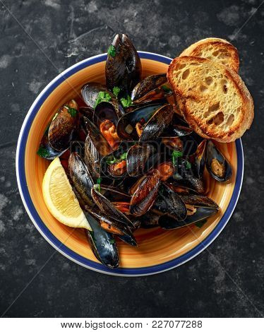 Mussels In Garlic Butter Sauce Served With Parsley, Toast And Lemon.