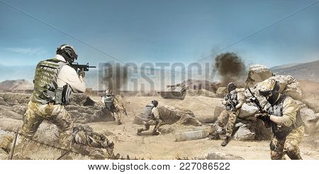Photo of a soldiers fighting and atacking on a desert battlefied background.