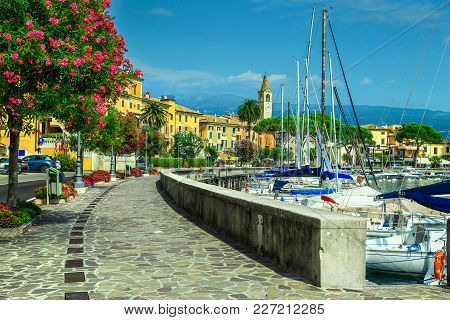 Stunning Paved Walkway With Colorful Mediterranean Flowers. Luxury Yachts And Boats In Wonderful Har