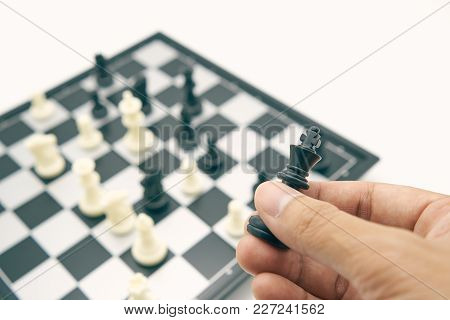 Businessman Holding A King Chess Is Placed On Chess Board.using As Background Business Concept And S