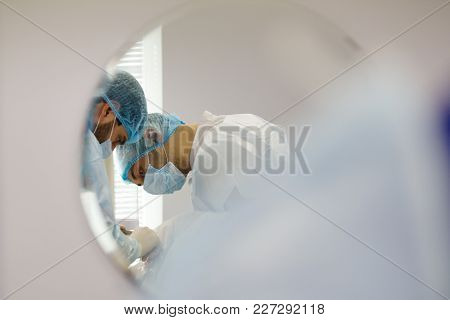Reflection In The Mirror - Doctor Dentist And Assistant During Stomatology Operation, Close Up