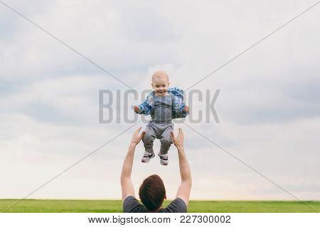 Joyful Man Walk On Green Field, Rest, Have Fun, Play, High Toss Up Little Cute Child Baby Boy On Sky