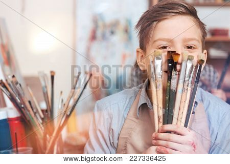 Cannot Sit Calm. Happy Teenager Having Fun While Looking Into The Camera And Posing With A Bunch Of 