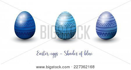 Three decorative three-dimentional glossy easter eggs in shades of blue. 