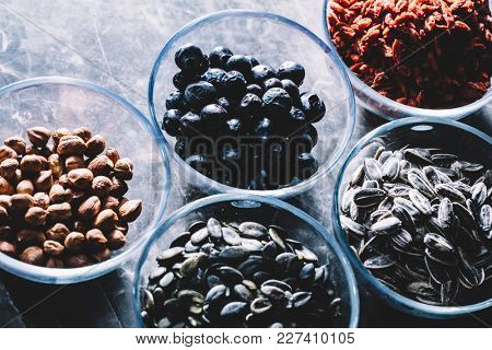 Five bowls with Brasilian nuts, blueberries, goji berries, pumpkin and sunflower seeds. Superfoods.