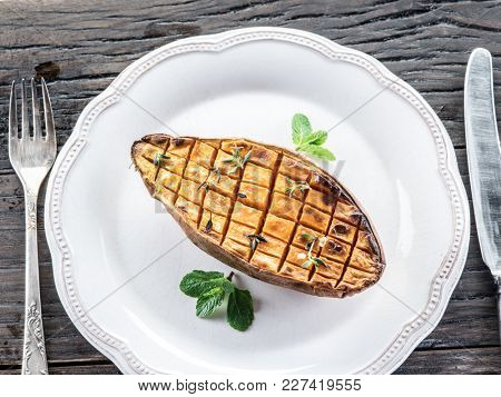 Baked batata on the old wooden table.