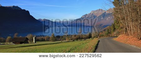 Autumn Scene In Brienz. Green Meadow, Houses And Lake Brienzersee. Mount Augstmatthorn. Landscape In