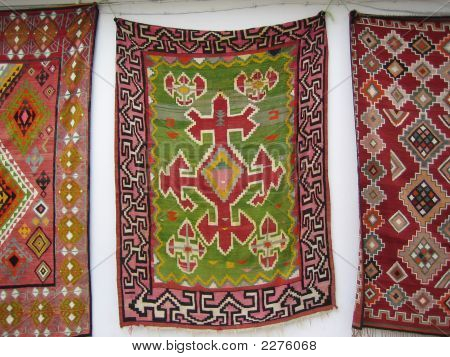 Tunisian Carpets Hanging Up On A White Wall