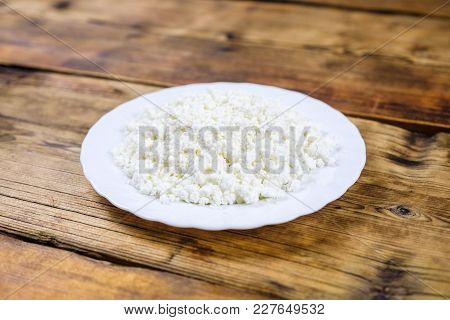 Home Made Large Cottage Cheese On White Plate On Wooden Background. Side View