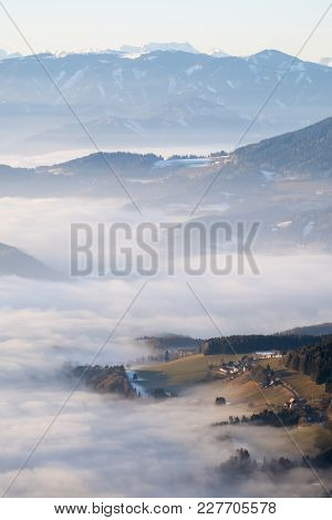 Hill Looking Through Low Stratus Fog With Mountain Range Hochschwab In The Background