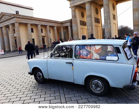 Berlin, Germany - December 3, 2017: The Retro Cat Trabant And The Brandenburg Gate