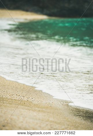 Blue Sea Water And Sandy Beach With Rock At Background, Selective Focus. Kleopatra Beach, Alanya, Tu