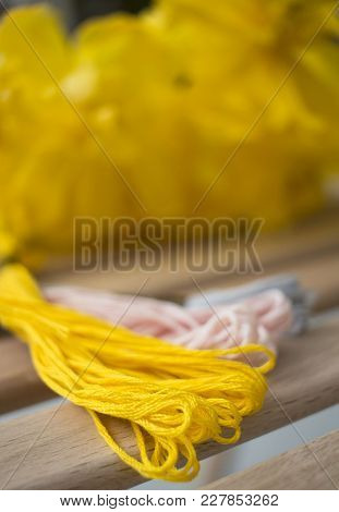 Yellow Thread For Embroidery On A Wooden Table