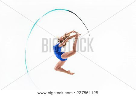 The Portrait Of Beautiful Young Brunette Woman Gymnast Training Calilisthenics Exercise With Blue Ri