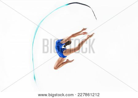 The Portrait Of Beautiful Young Brunette Woman Gymnast Training Calilisthenics Exercise With Blue Ri