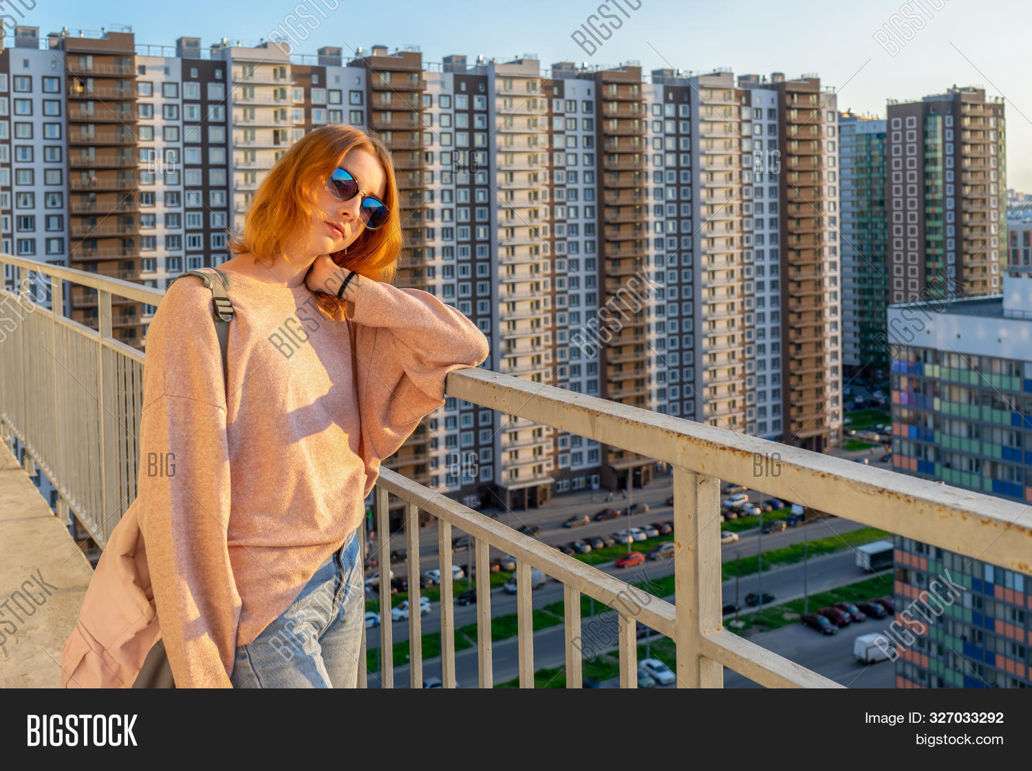 Девушка в джинсах гуляет на балконе 