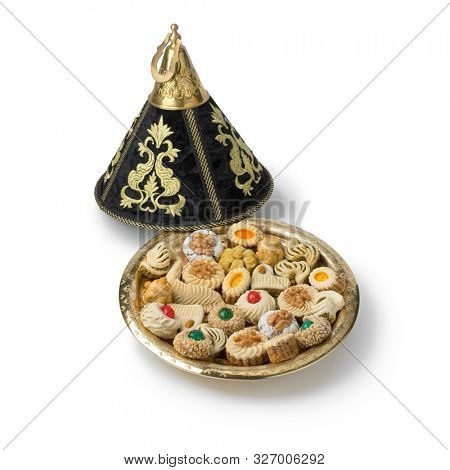 Diversity of traditional festive Moroccan cookies in a party tagine isolated on white background