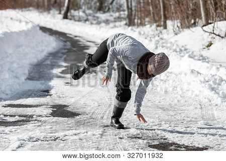 Woman Is Falling On The Icy Road At The Winter Season, Black Ice And Danger
