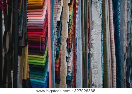 Many Fabrics Of Different Types. Colorful Fabric Swatches On Shopfront. Textile Samples Background.