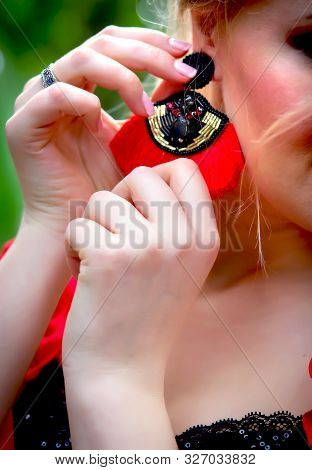 Girl Holds Hand With A Beautiful Modern Red Earring With Stones