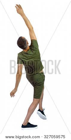 Side view of a man dancing in shorts. The guy is balancing. Rear view people collection. backside view of person. Isolated over white background. A guy in green shorts falls back slipping.