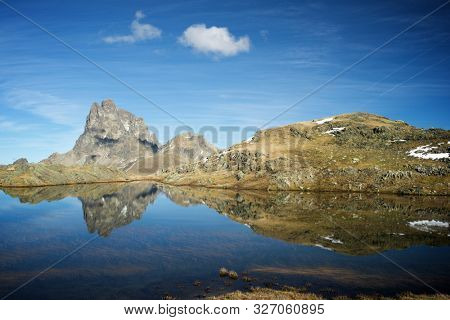 Midi Dossau Peak reflected in a lake. Ossau Valley, Pyrenees National Park, Pyrenees, France.