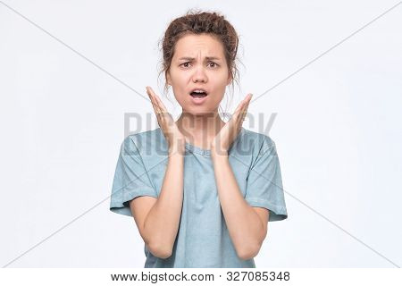 Asian Young Female Student Raises Hands Up And Looks In Bewilderment, Being Dissatisfied